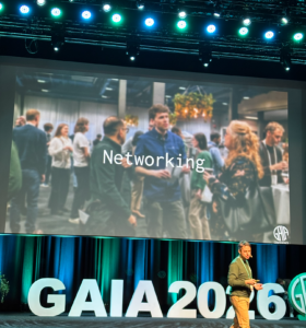 Presentation från scenen på GAIA 2026 om mässans syfte, med en slide om networking där Håkan Åkerblom från Contica och kollegan Ahmed Bayoumy syns på ett foto från fjolårets event